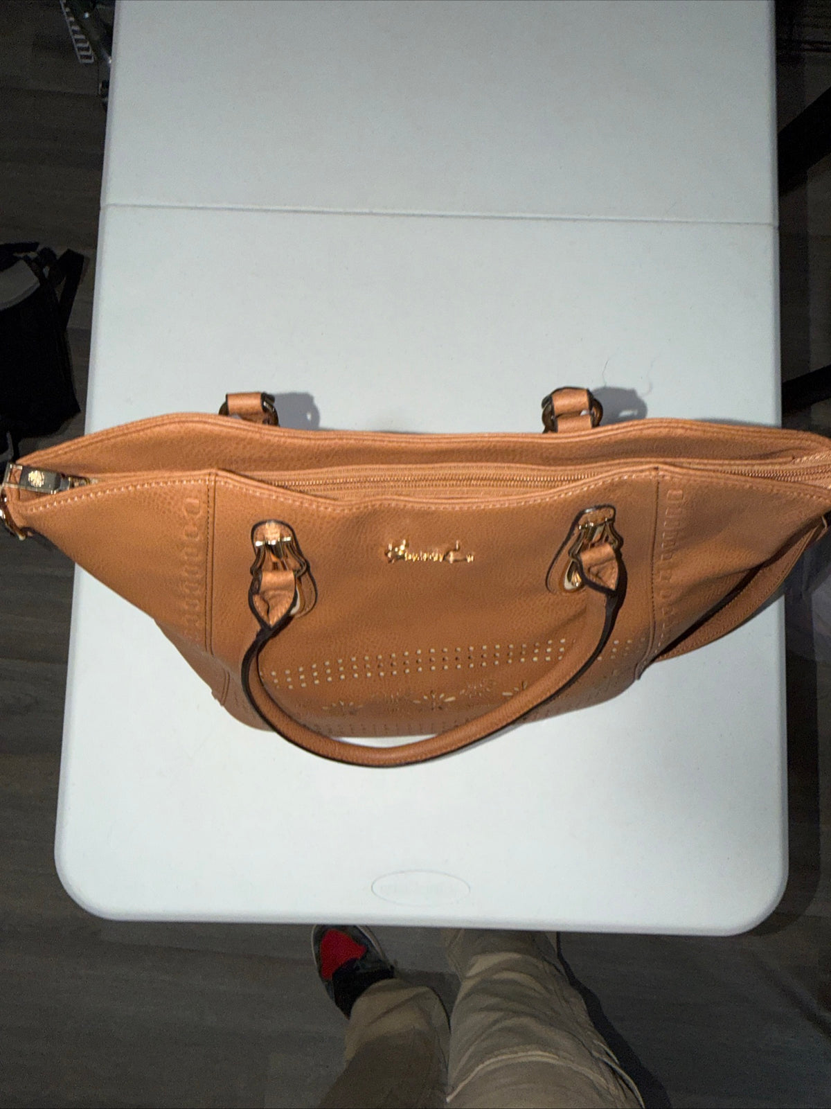 LerssaCi Tan Handbag With perforated floral cutouts and gold-toned hardware.